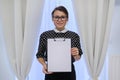 Mature smiling successful business woman showing blank paper on clipboard Royalty Free Stock Photo