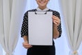 Mature smiling successful business woman showing blank paper on clipboard Royalty Free Stock Photo