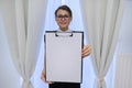 Mature smiling successful business woman showing blank paper on clipboard Royalty Free Stock Photo