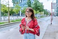 Mature smiling woman in embroidered shirt looking at camera, on street of modern city Royalty Free Stock Photo