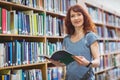 Mature student reading book in library wearing smart watch Royalty Free Stock Photo