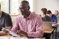 Mature Student Using Digital Tablet In Adult Education Class Royalty Free Stock Photo