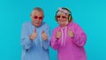 Mature stylish grandparents pensioners listening music via headphones, dancing disco fooling around Royalty Free Stock Photo