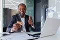 Mature successful businessman smiling and looking at camera, showing thumbs up, holding bank credit card, using laptop Royalty Free Stock Photo