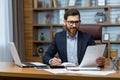 Mature successful financier working inside office at workplace with contracts and papers businessman behind paper work Royalty Free Stock Photo