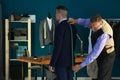 Mature tailor taking client's measurements in atelier