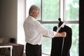 Mature tailor taking measurements of male jacket on mannequin in atelier Royalty Free Stock Photo