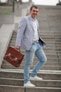 Businessman walking on the stairs background. Business man in a classy suit holding briefcase. Classic business concept.