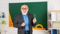 Mature teacher enjoying job. Sharing knowledge. More tools introduced into everyday classrooms. Senior man teacher at Royalty Free Stock Photo