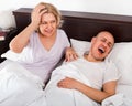 Mature tired girl looking at snoring boyfriend Royalty Free Stock Photo