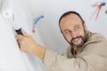 Mature tradesman using paint roller