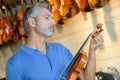 Mature violin maker while testing violins in laboratory Royalty Free Stock Photo