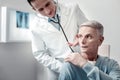 Worried old male putting hand on sick shoulder