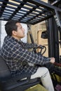 Mature Warehouse Worker Driving Forklift Royalty Free Stock Photo