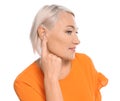 Mature woman adjusting hearing aid on white Royalty Free Stock Photo