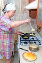 Mature woman bakes pancakes