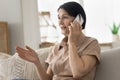 Mature woman blab on cellphone seated on couch Royalty Free Stock Photo