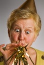 Mature woman blowing party horn Royalty Free Stock Photo