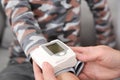 Mature woman checking little boy`s pulse with medical device indoors Royalty Free Stock Photo