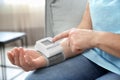 Mature woman checking pulse with medical device at home