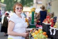 Mature woman chooses fruits