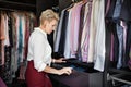 Mature woman chooses or organizes clothes and things in drawer in wardrobe closet dressing room at home