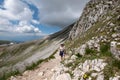 Mature woman is climbing the trail to Duca degli Abruzzi Lodge, Italy