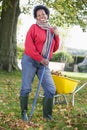 Mature woman collecting leaves in garden