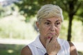 Mature woman concerned with hand on chin looking pensive Royalty Free Stock Photo