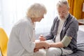 Mature woman controlling blood pressure of husband using stethoscope