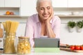 Mature woman cooking while using tablet computer Royalty Free Stock Photo