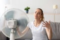 Mature woman cooling herself in front of fan during hot weather Royalty Free Stock Photo