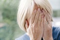 Mature woman covering her face with her hands. Royalty Free Stock Photo