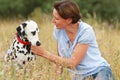 Mature woman is cuddling a dalmatian dog in a meadow outdoor Royalty Free Stock Photo