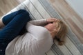 Mature woman curled lying on the bed at home top view. Depression, mental health, abuse problem Royalty Free Stock Photo