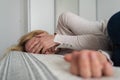 Mature woman curled lying on the bed at home top view. Depression, mental health, abuse problem Royalty Free Stock Photo