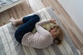 Mature woman curled lying on the bed at home top view. Depression, mental health, abuse problem Royalty Free Stock Photo