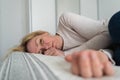 Mature woman curled lying on the bed at home top view. Depression, mental health, abuse problem Royalty Free Stock Photo