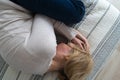 Mature woman curled lying on the bed at home top view. Depression, mental health, abuse problem Royalty Free Stock Photo