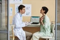 Mature woman with doctor during consultation in dermatology clinic