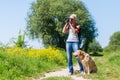 Mature woman with dog taking photos with a camera