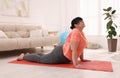 Overweight mature woman doing exercise on yoga mat at home Royalty Free Stock Photo