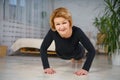 Mature woman doing push-UPS at home, healthy lifestyle concept Royalty Free Stock Photo