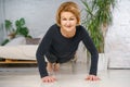 Mature woman doing push-UPS at home, healthy lifestyle concept Royalty Free Stock Photo