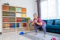 Retirement woman doing exercise with Squats pose at home