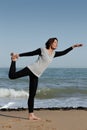 Mature woman doing yoga Lord of the Dance on the b Royalty Free Stock Photo
