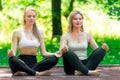 mature woman doing yoga in lotus pose with trainer individually