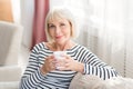 Mature woman drinking fresh morning coffee at home