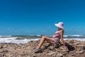 Mature woman enjoying a sunny summer day relaxing on the rocks near the sea. Royalty Free Stock Photo