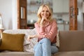 Mature Woman Enjoying Time At Home Sitting On Cozy Couch Royalty Free Stock Photo